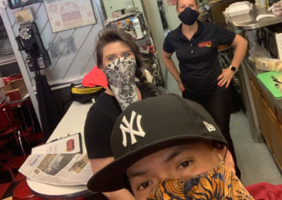 A selfie of restaurant staff wearing cloth masks